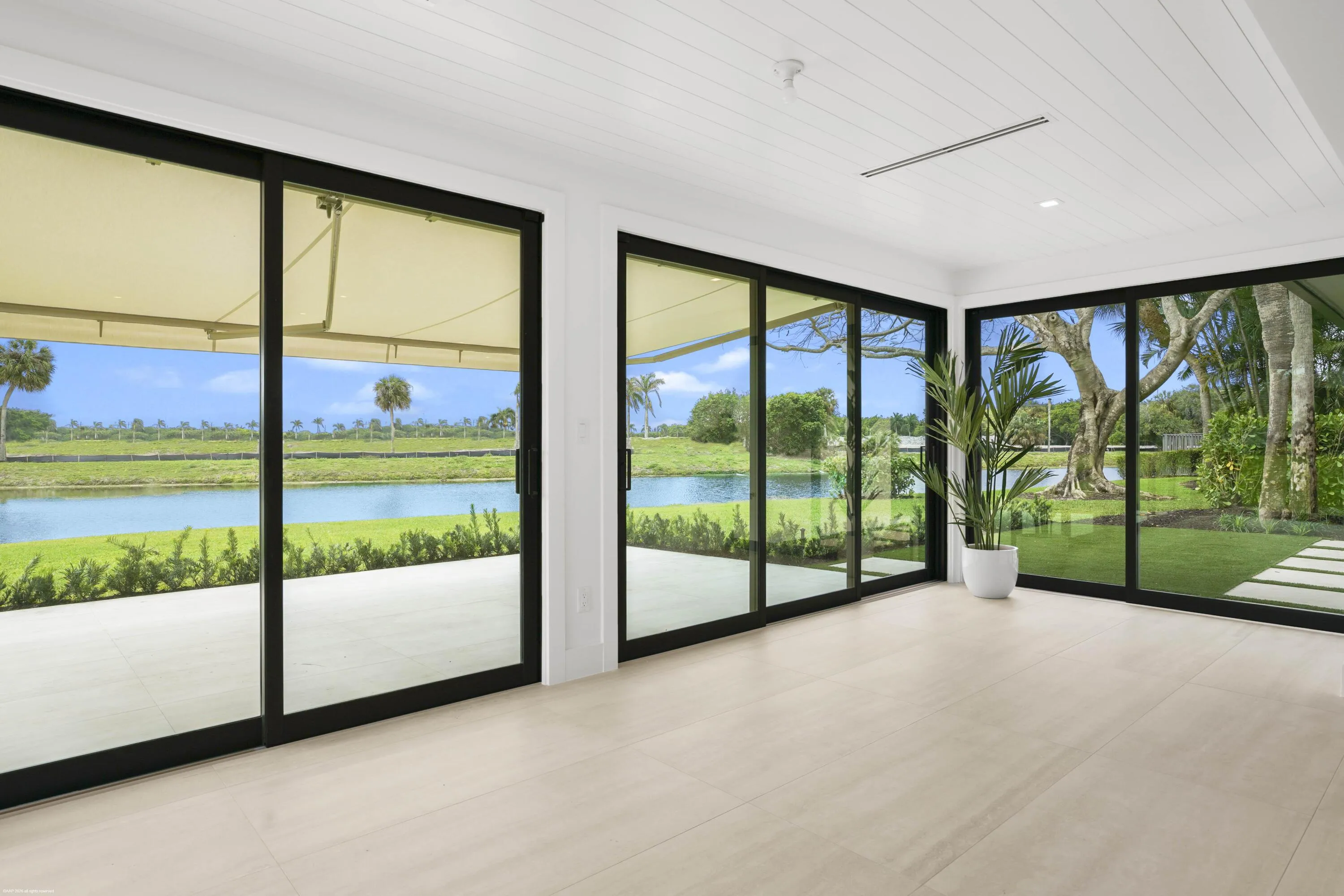 Expansive glass sliding doors, wood-finish flooring, white shiplap ceiling, and recessed lighting