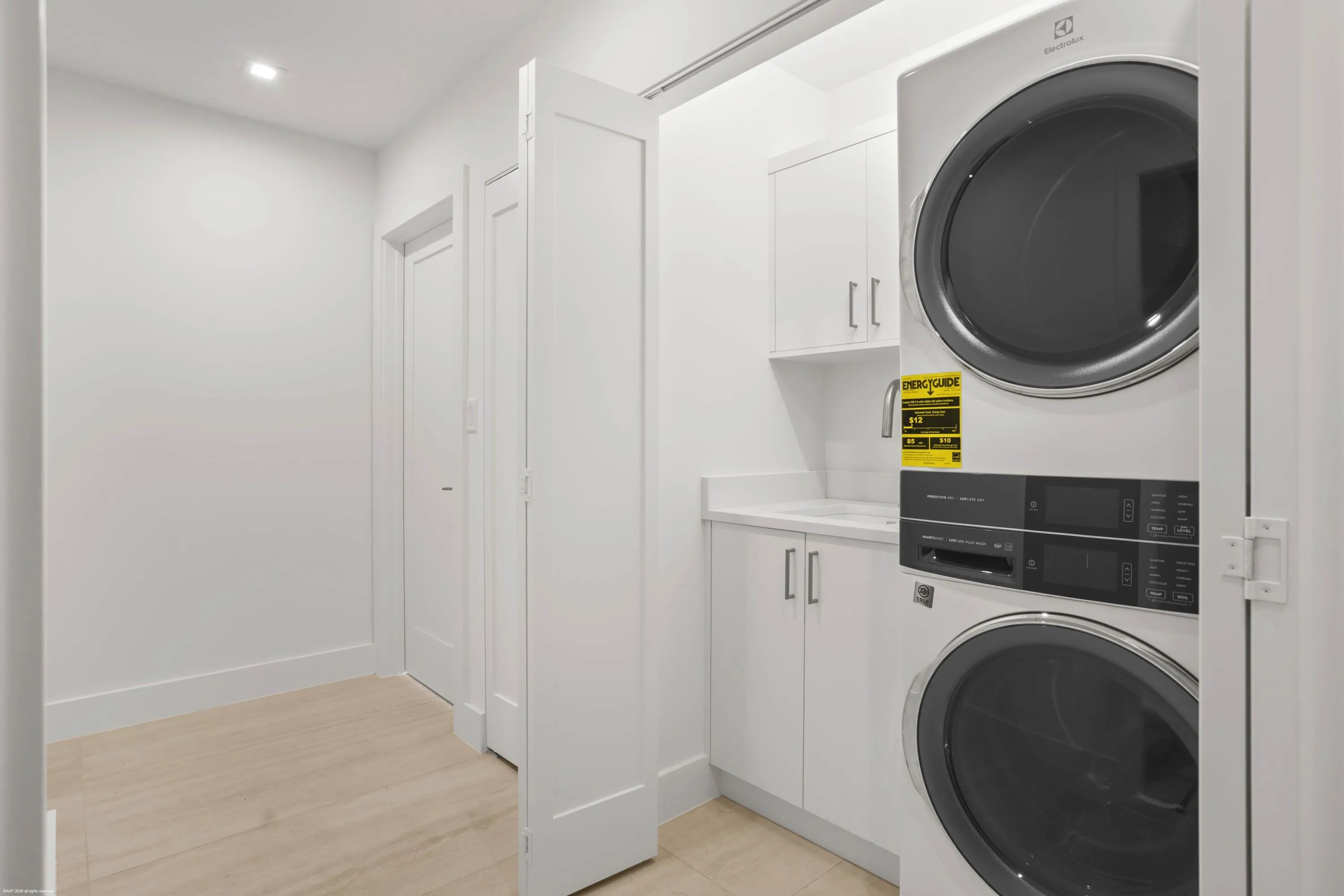 Integrated laundry appliances with white cabinetry, a single basin sink, and a countertop work surface
