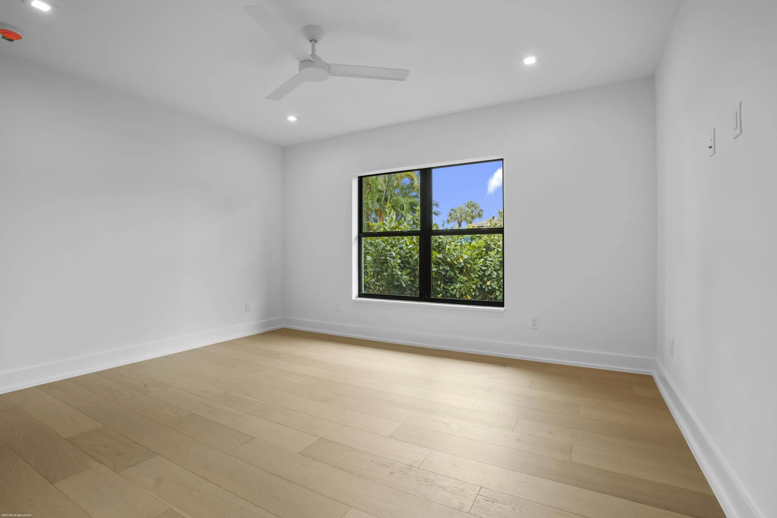 Hardwood flooring, recessed lighting, ceiling fan, and a large window with exterior landscaping