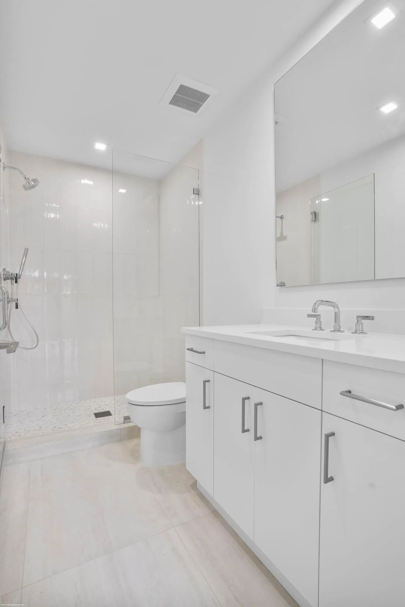 White vanity with brushed nickel hardware, integrated sink, and wall-mounted mirror