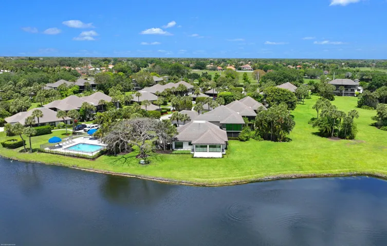 Waterfront property with private pool and expansive green spaces surrounded by mature trees
