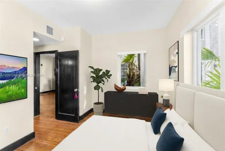 bedroom with hallway leading to en suite bath
