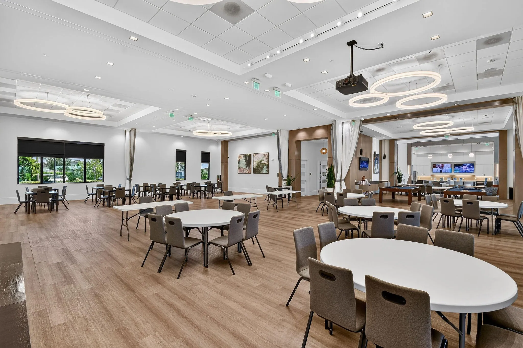 Expansive multipurpose room featuring wood-finish flooring, recessed lighting, and multiple windows