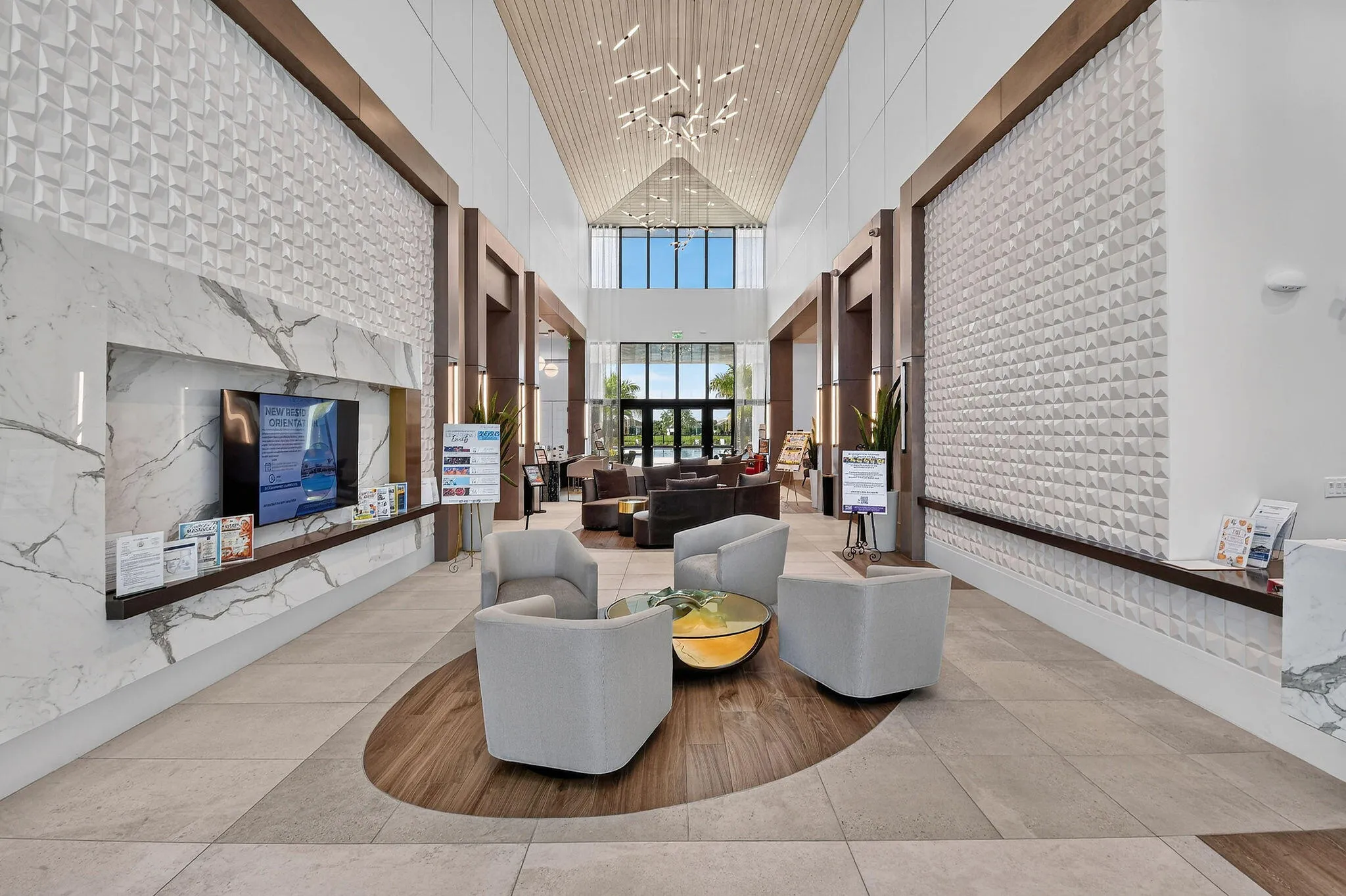 Expansive interior space featuring a high vaulted ceiling, integrated wood-finish beams, and geometric textured wall panels