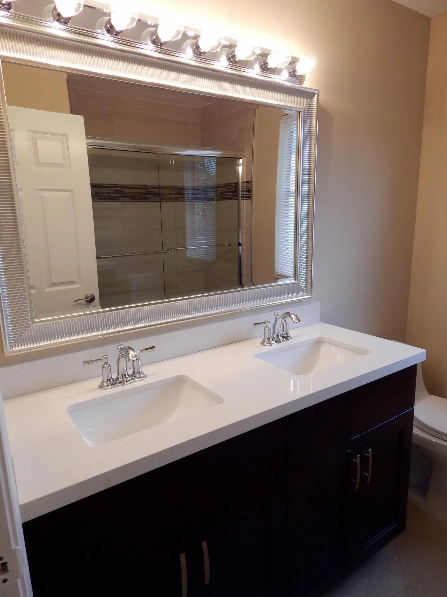 Dual vanity featuring white countertops, undermount sinks, and chrome faucets