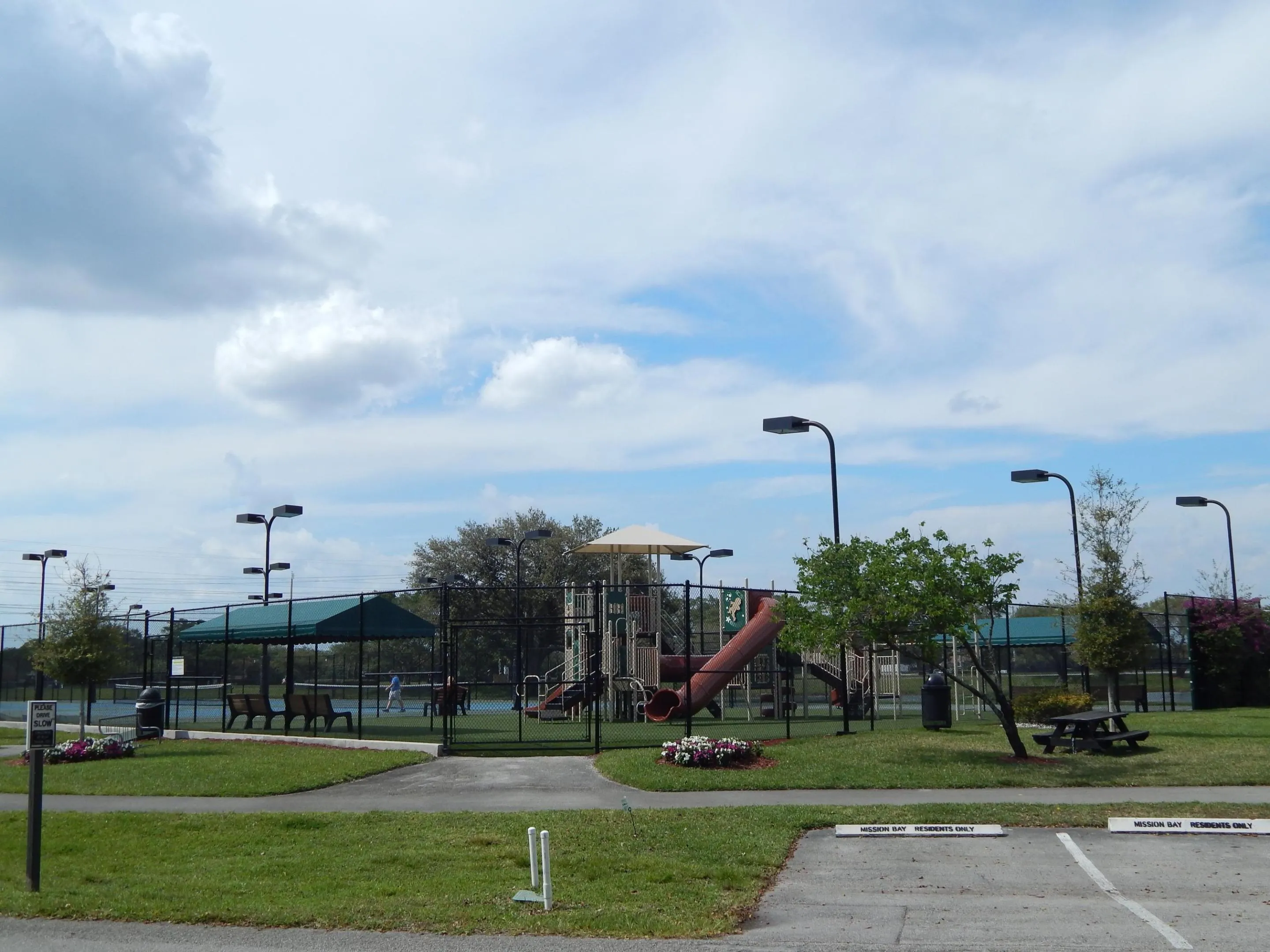 Community amenities featuring a playground, tennis courts, covered seating area, and picnic table