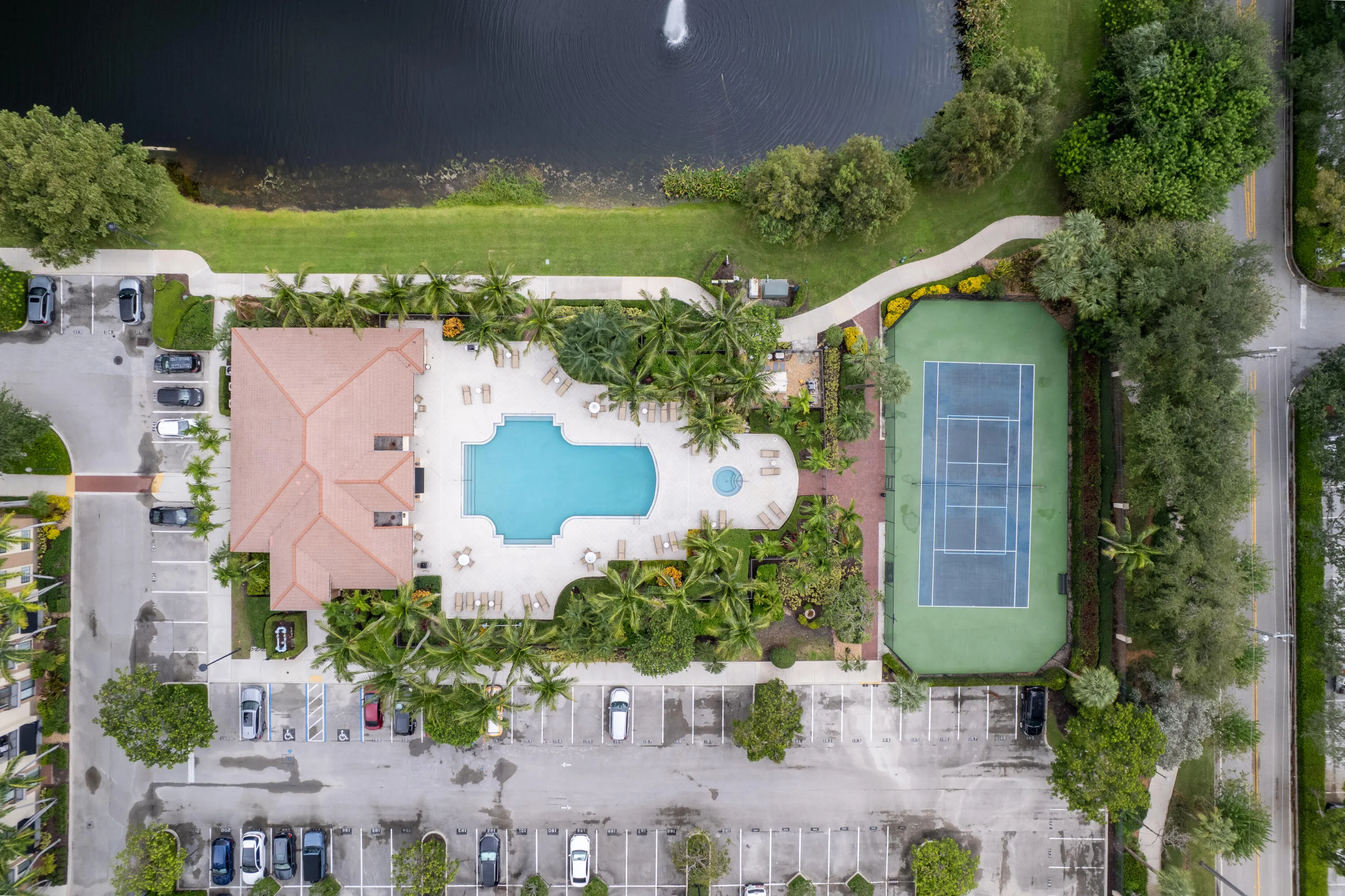 Community amenities featuring a swimming pool, tennis court, and parking areas