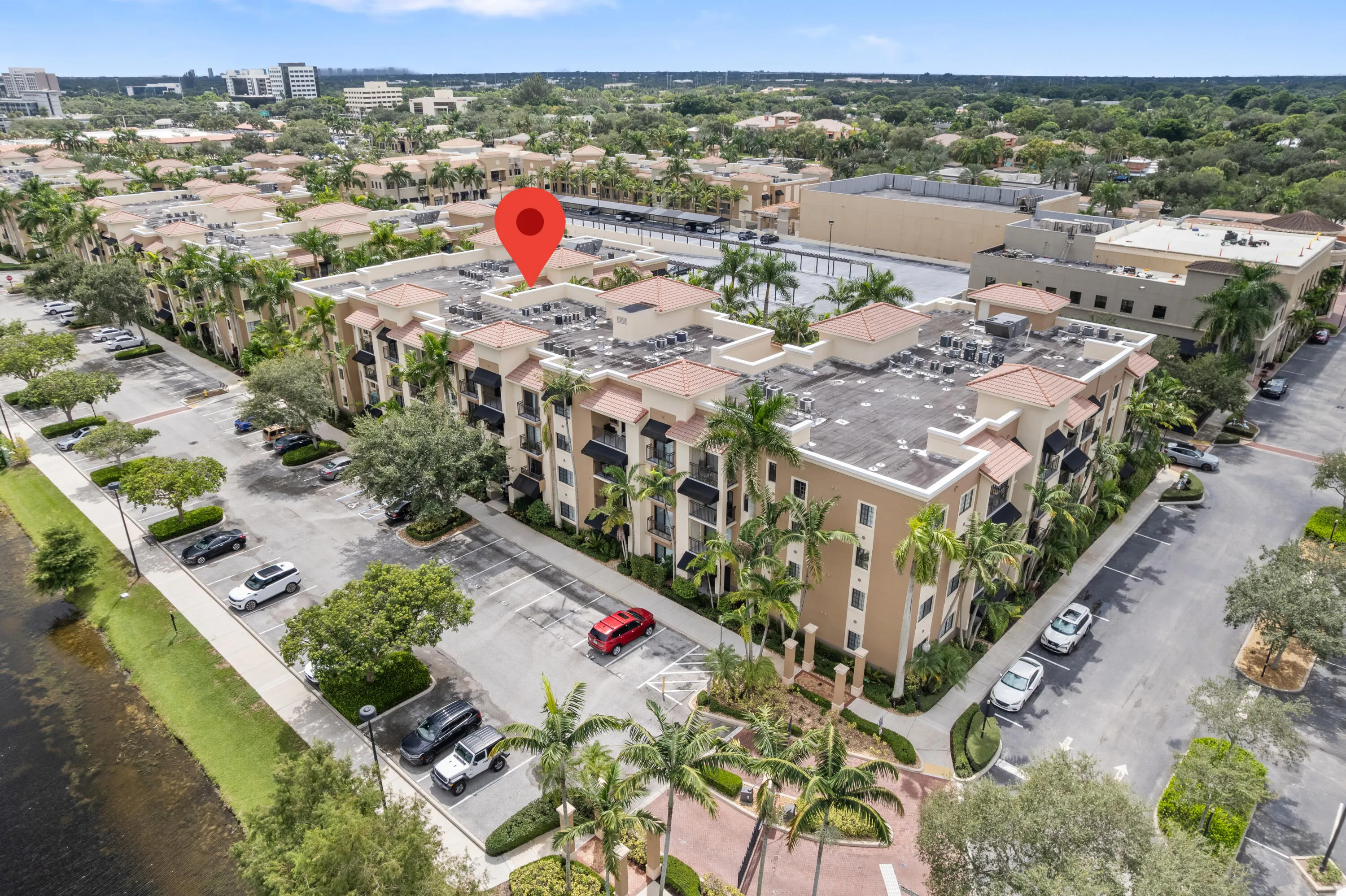 Multi-story building featuring Mediterranean-inspired architecture, multiple balconies, and a flat roof with tile accents