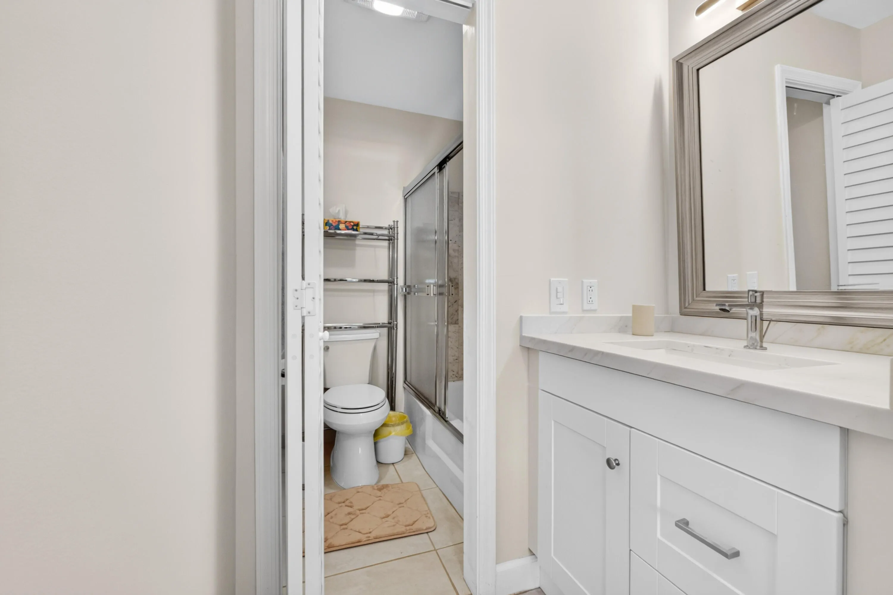 Modern bathroom featuring a white vanity with dual-drawer storage, white quartz countertop, and chrome faucet hardware