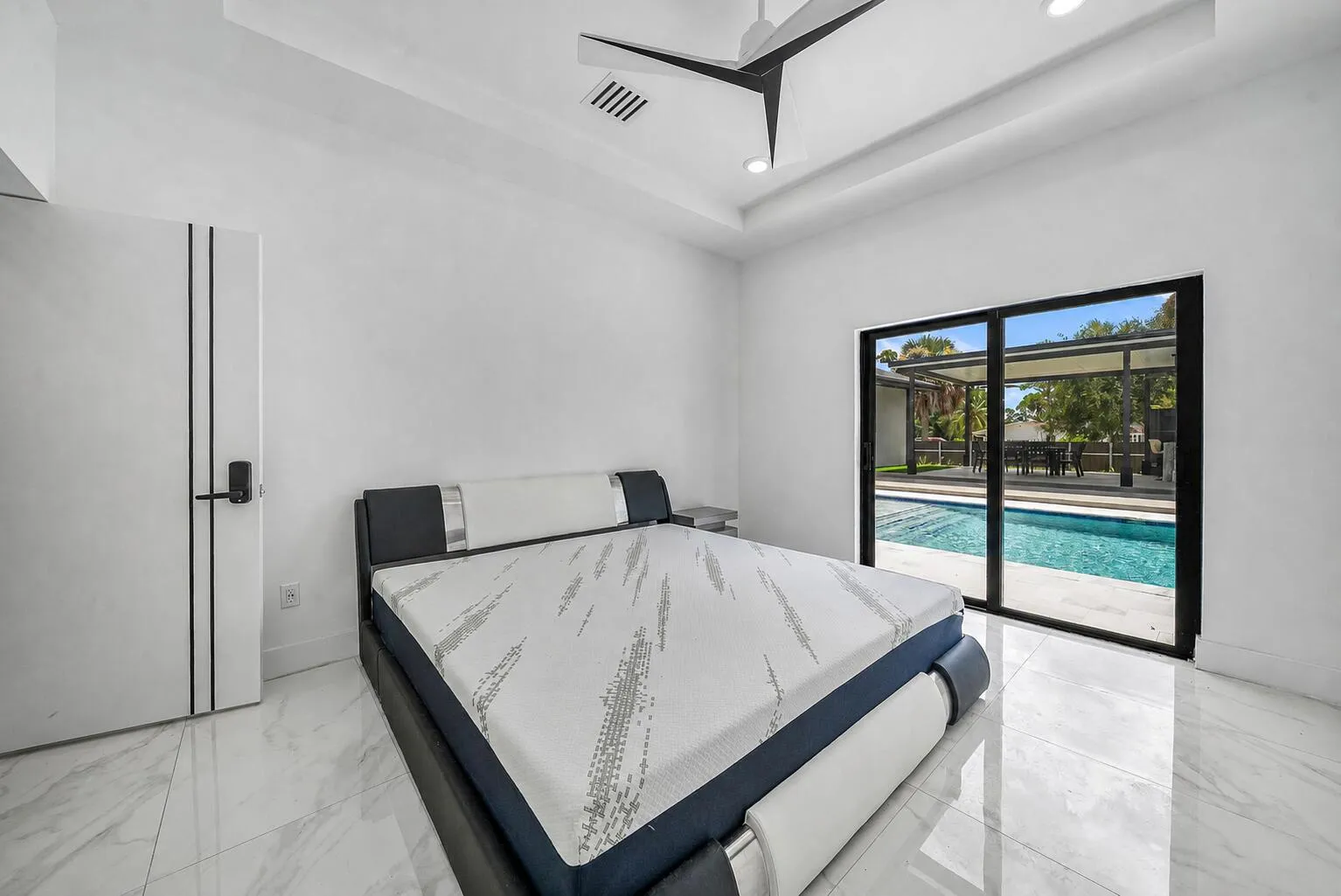 White walls with a tray ceiling, recessed lighting, and a modern ceiling fan