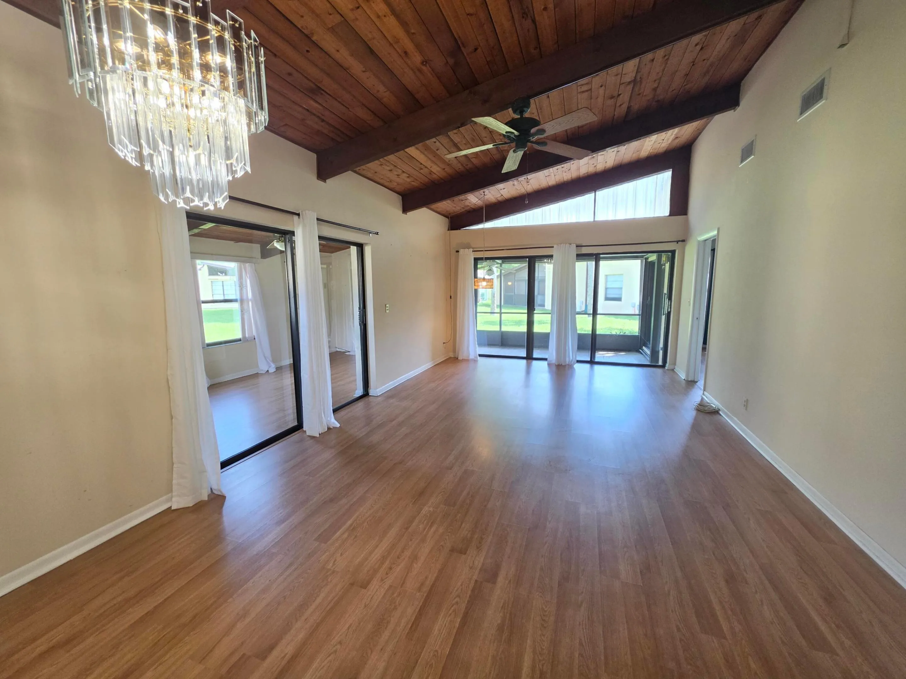 STUNNING FROM EVERY ANGLE, YOUR MAIN LIVING SPACE PROVIDES A SEPARATE FLEX ROOM, OVER SIZED SLIDER DOORS, HIGH CEILINGS WITH BEAUTIFUL EXPOSED WOOD AND BEAMS AND SPARKLING CHANDELIER.