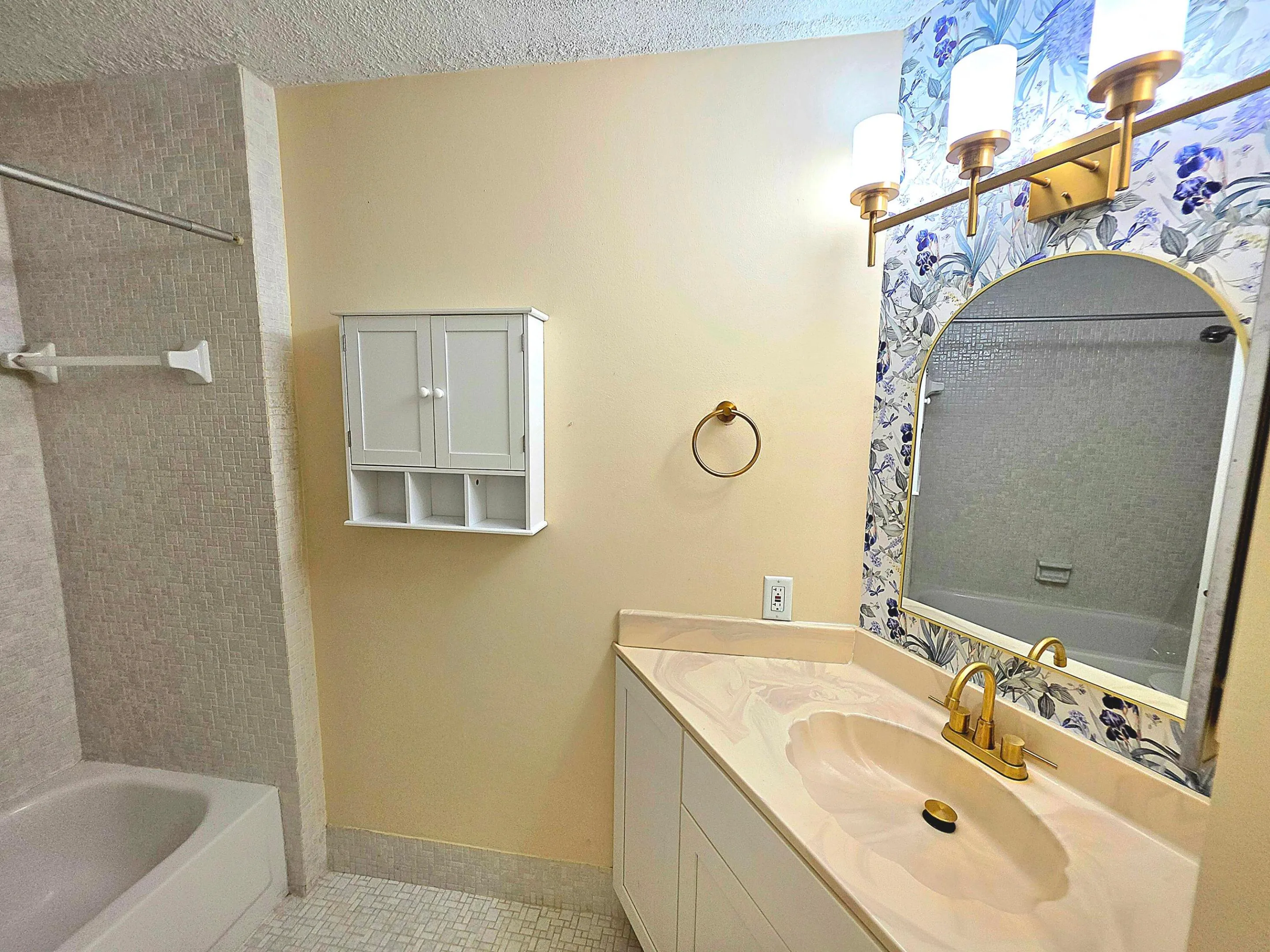 THIS BATH BOASTS GOLD FINISHES AND FLOOR TO CEILING TILE AS WELL UNIQUE ACHITECTURAL ANGLES.