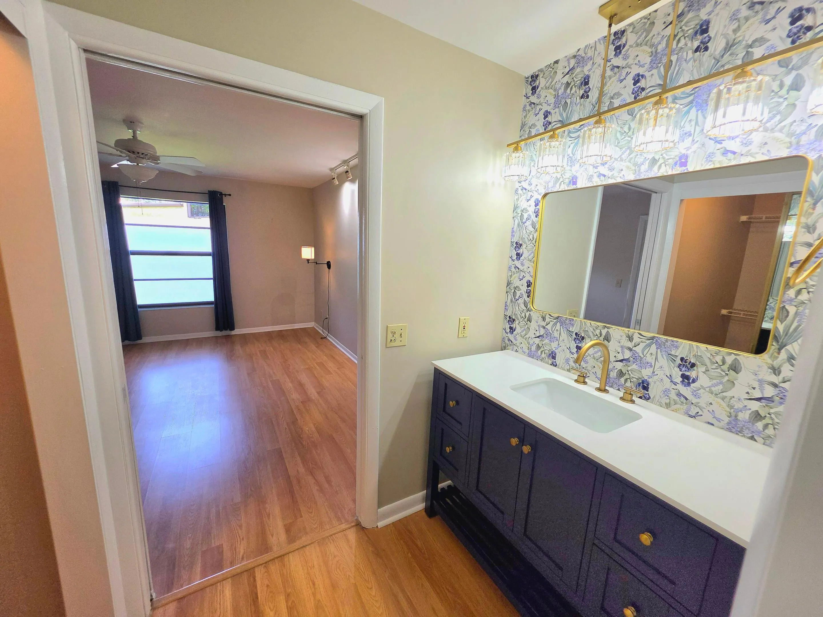 THE STUNNING LAMINATE FLOORING CONTINUES INTO THE PRIMARY BATH AND WALK IN CLOSET.
