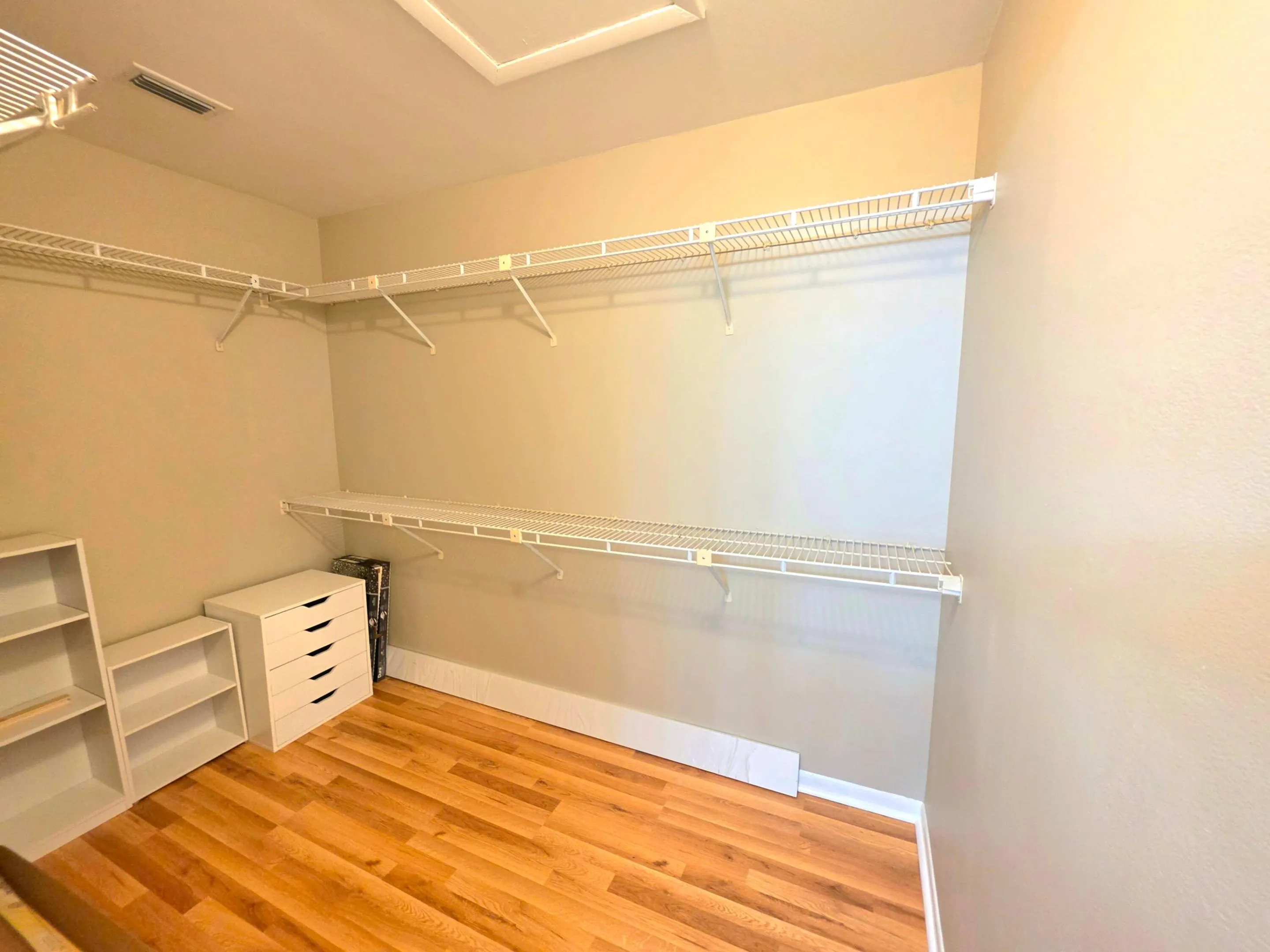 THE OVERSIZED WALK IN CLOSET OFFERS LAMINATE FLOORING AND PLENTY OF STORAGE.