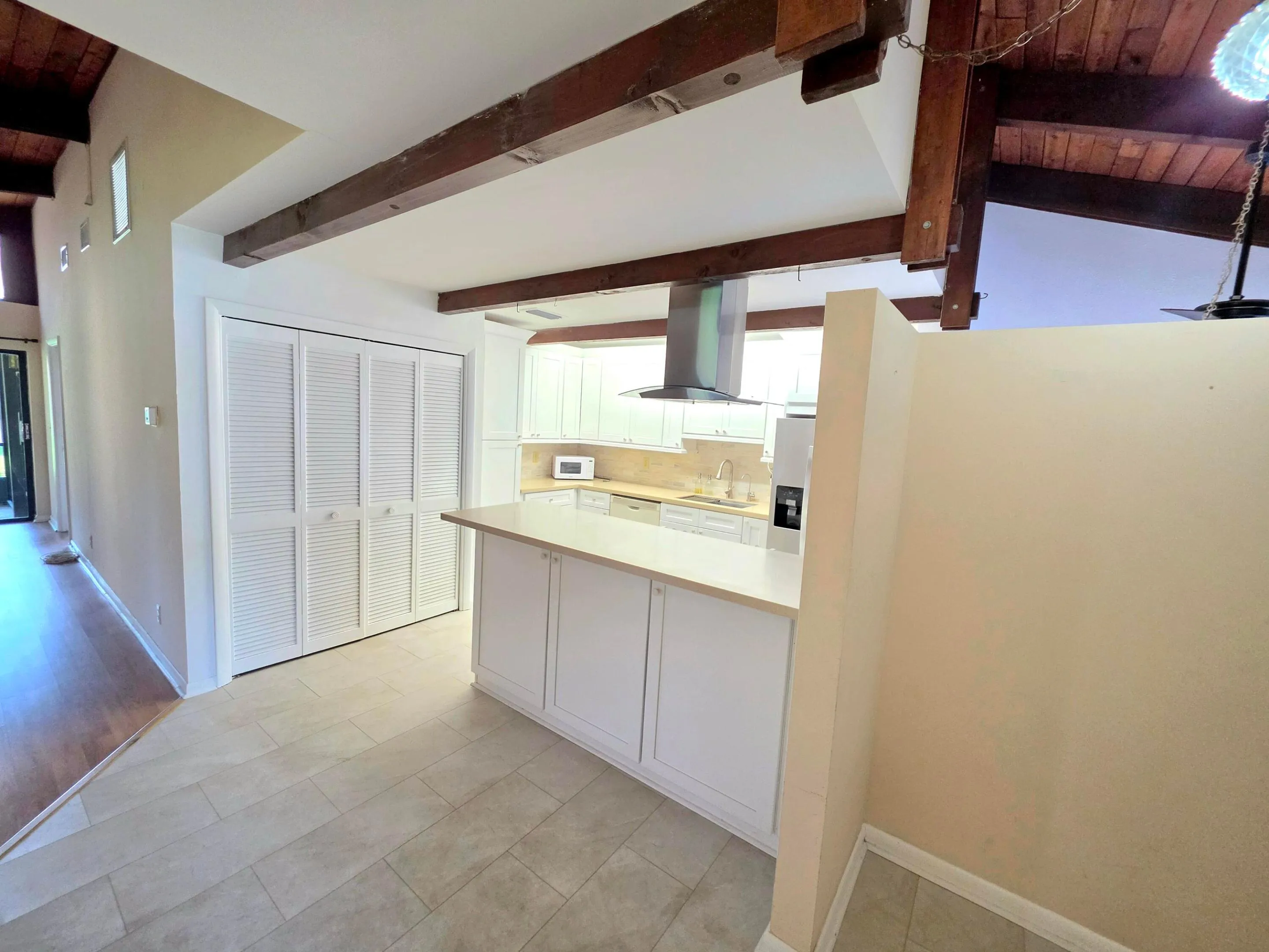 THE FRONT FOYER OPENS TO HIGH CEILINGS, PLENTY OF NATURAL LIGHT AND VIEWS OF THE BACK GARDEN AREAS.