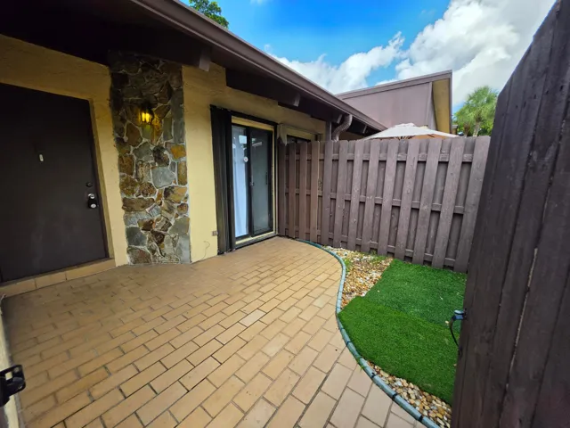 PAVER PATIO, SEPARATE ENTRANCE TO THE KITCHEN AND HIGH FENCING CREATING THE PERFECT SPOT FOR MORNING COFFEE OR EVENING BEVERAGES.