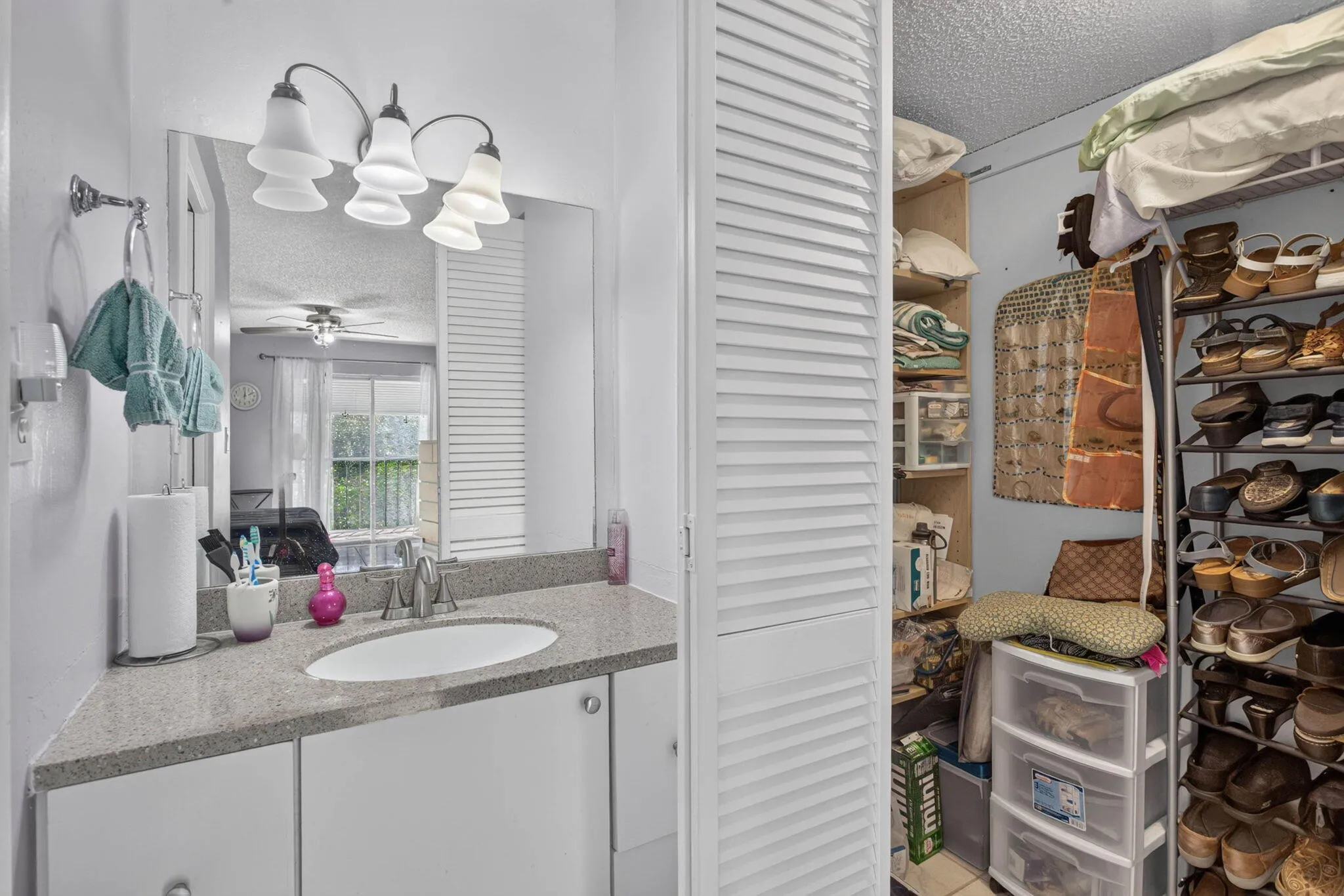 2nd Closet in Primary suite plus Vanity with a single basin sink, specked countertop, and a three-light fixture