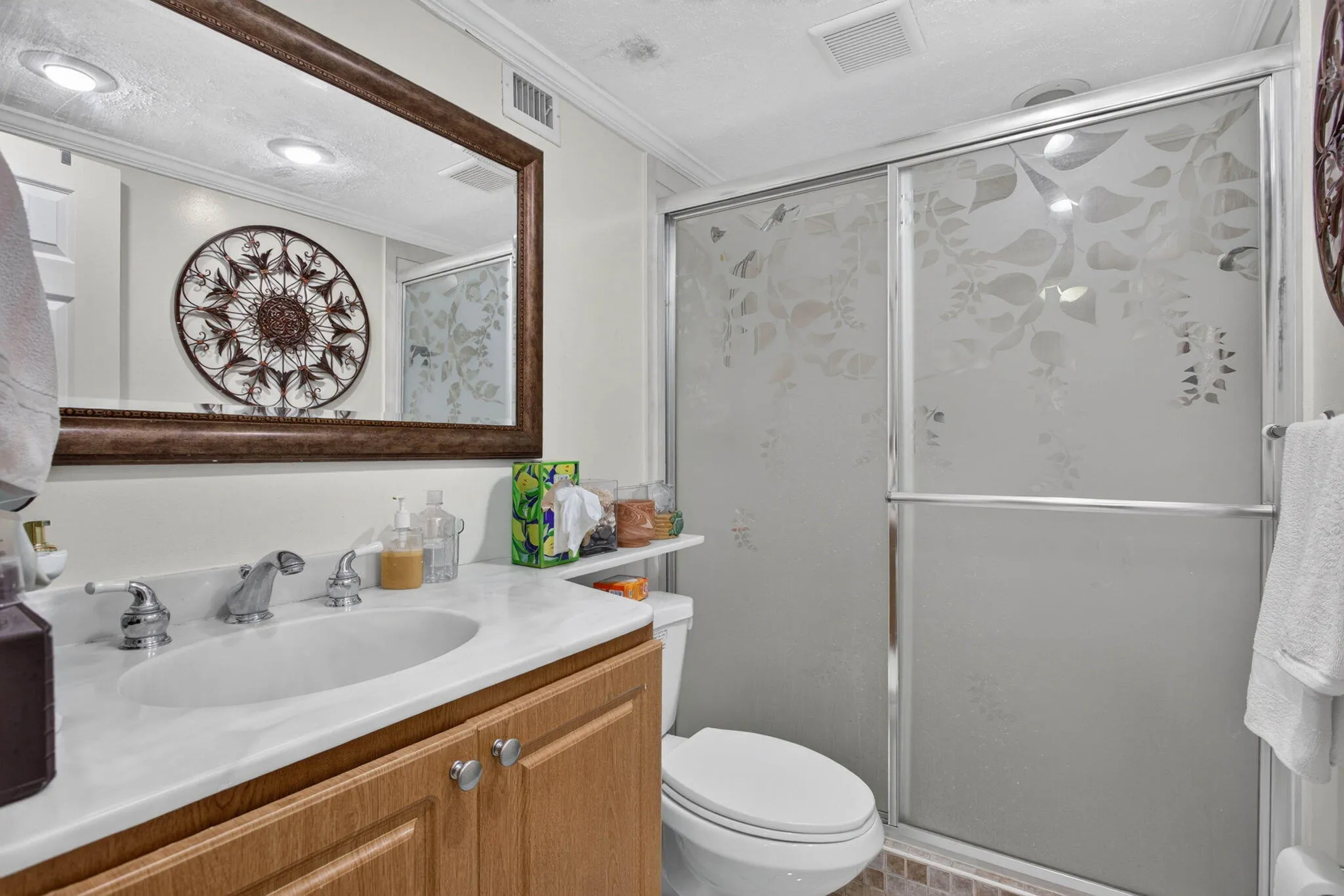 Vanity with white countertop, chrome faucet, and wood-finish cabinetry