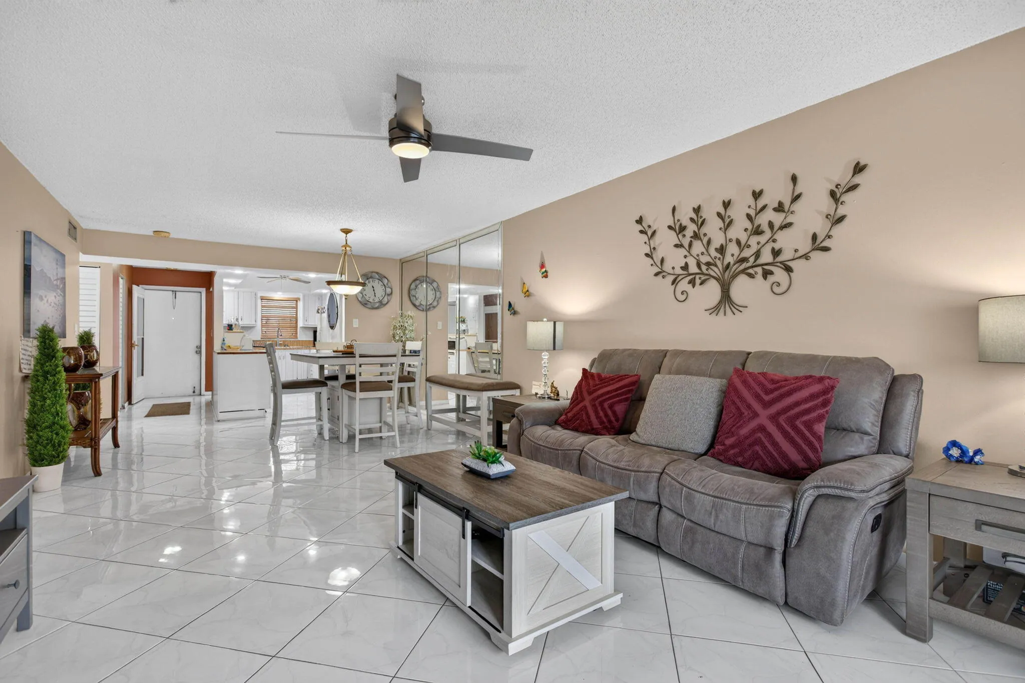 Expansive living area with tile flooring, a modern ceiling fan, and recessed lighting