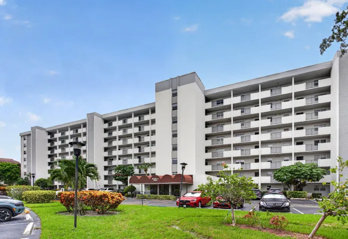 Multi-story residential building with private balconies and a covered entryway