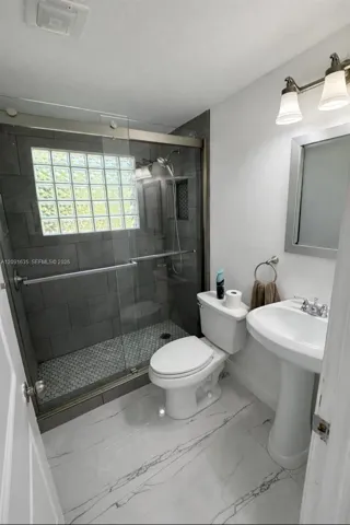 Fully updated bathroom featuring contemporary fixtures and a sleek frameless glass shower enclosure.