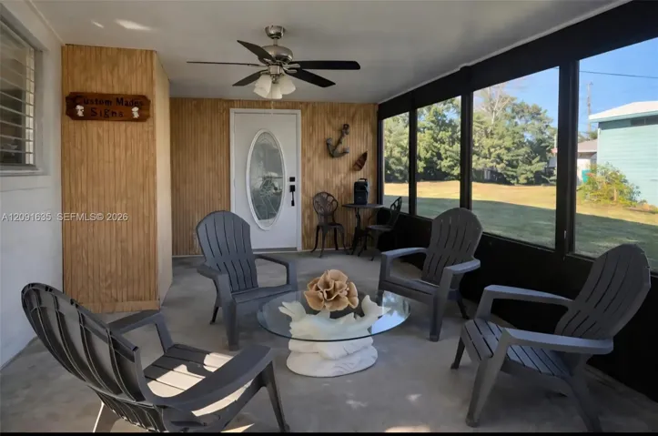 Relaxing screened-in porch / sunroom overlooking the private backyard, ideal for year-round outdoor enjoyment.