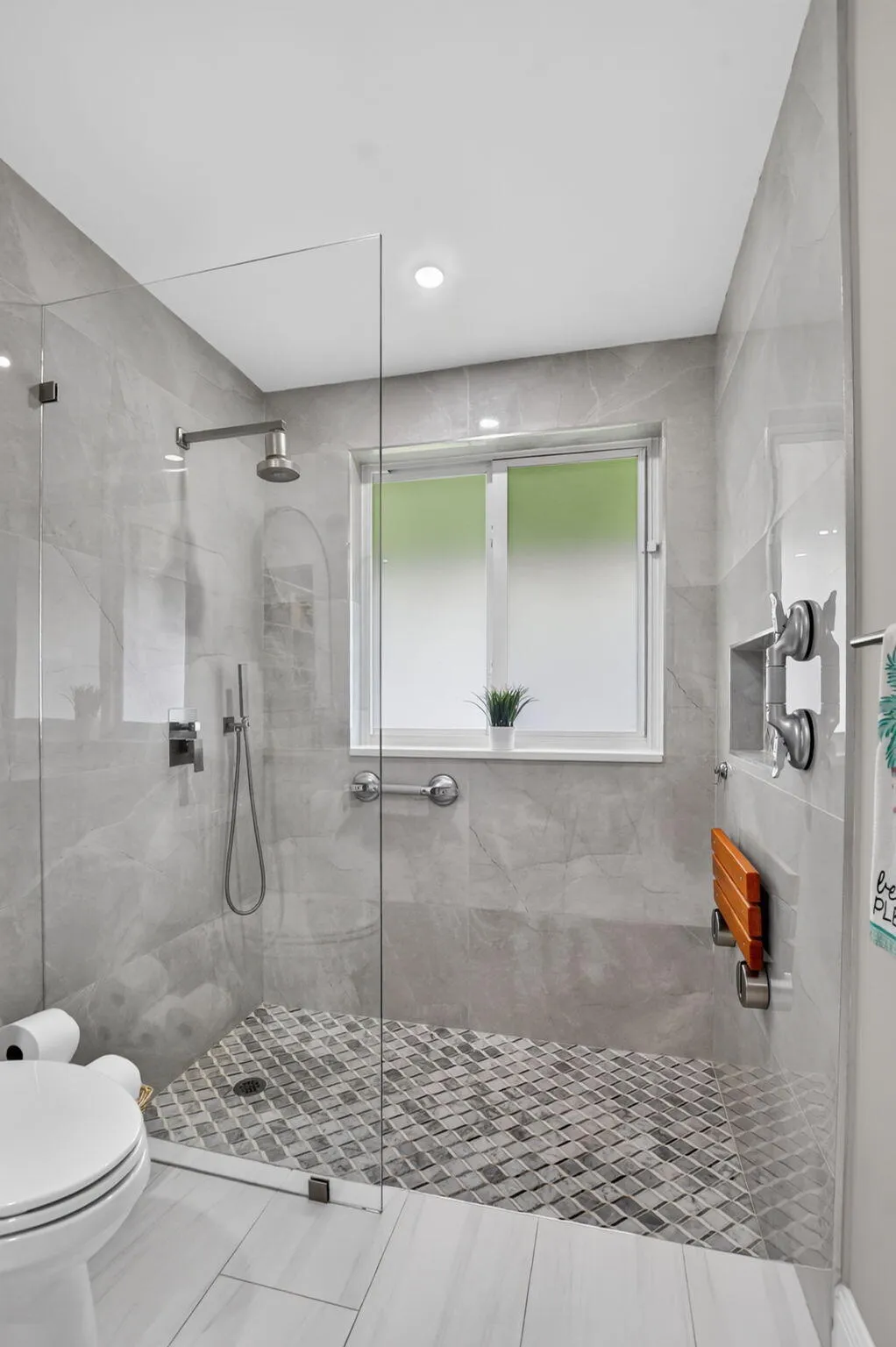 Gorgeous primary bath boasts dual shower heads, and elegant, oversized porcelian shower walls.