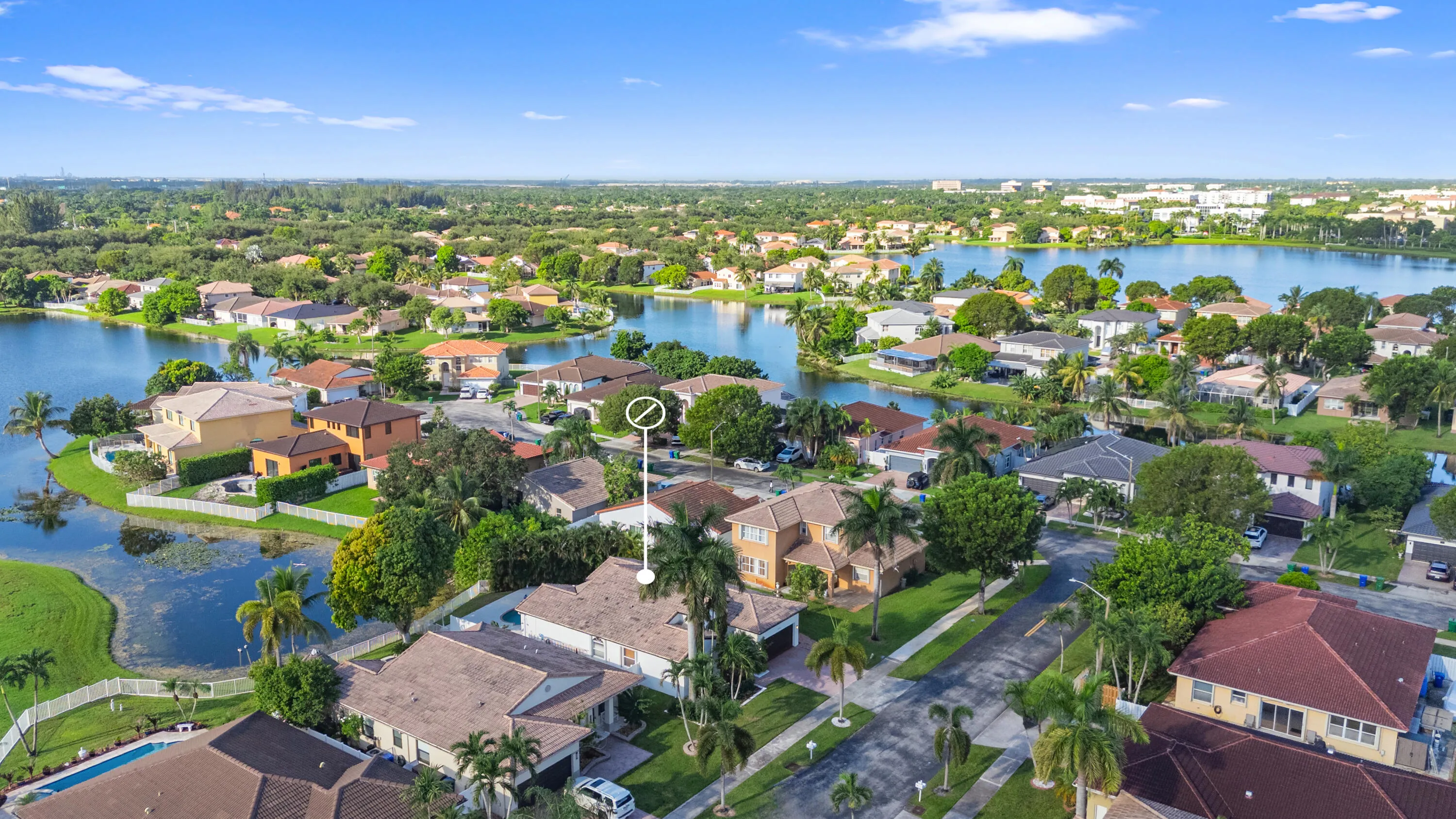 Expansive aerial view highlights the surrounding residential community and network of lakes.