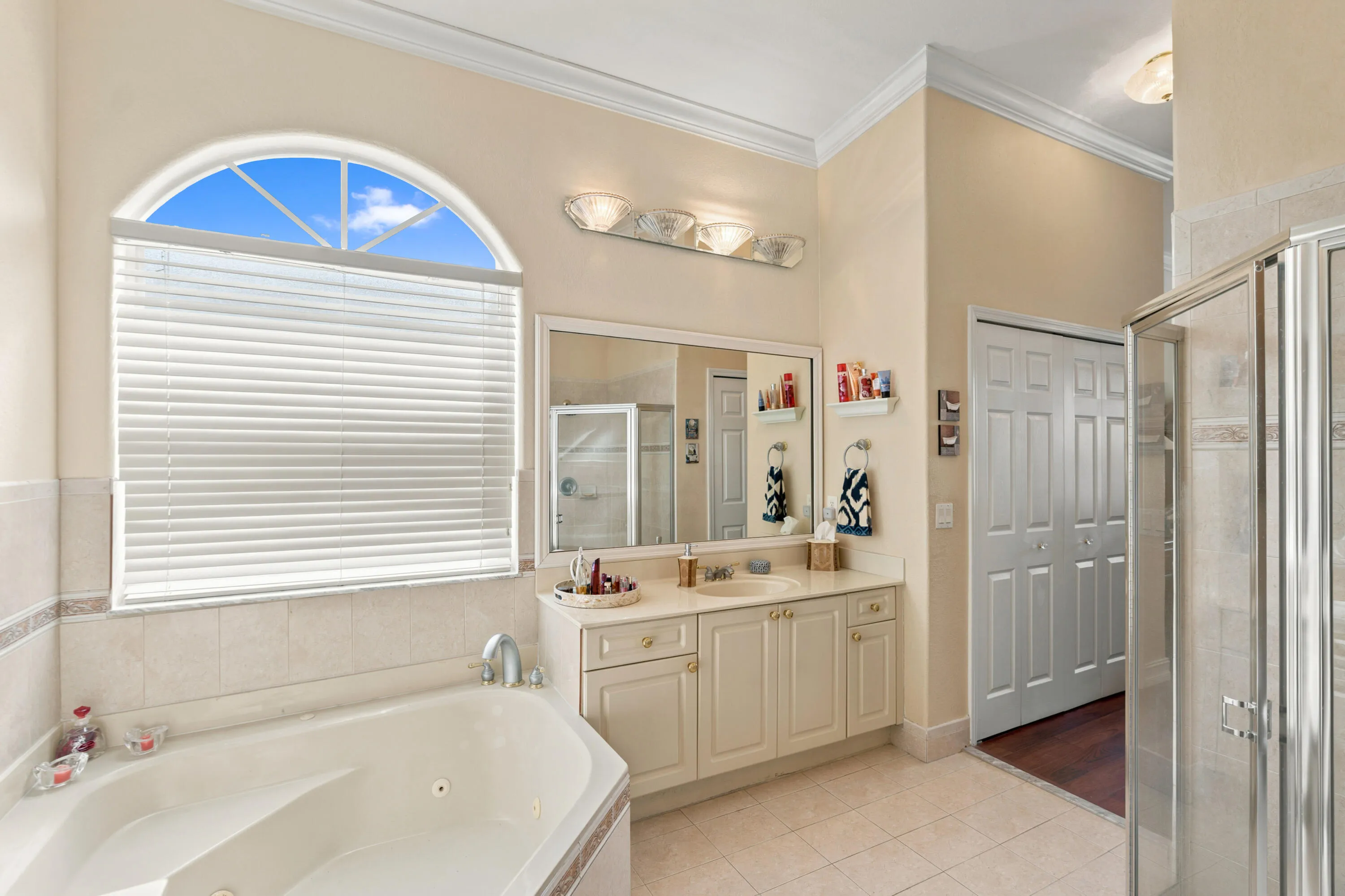 Natural light fills the bath, highlighting the soaking tub, vanity and separate shower.