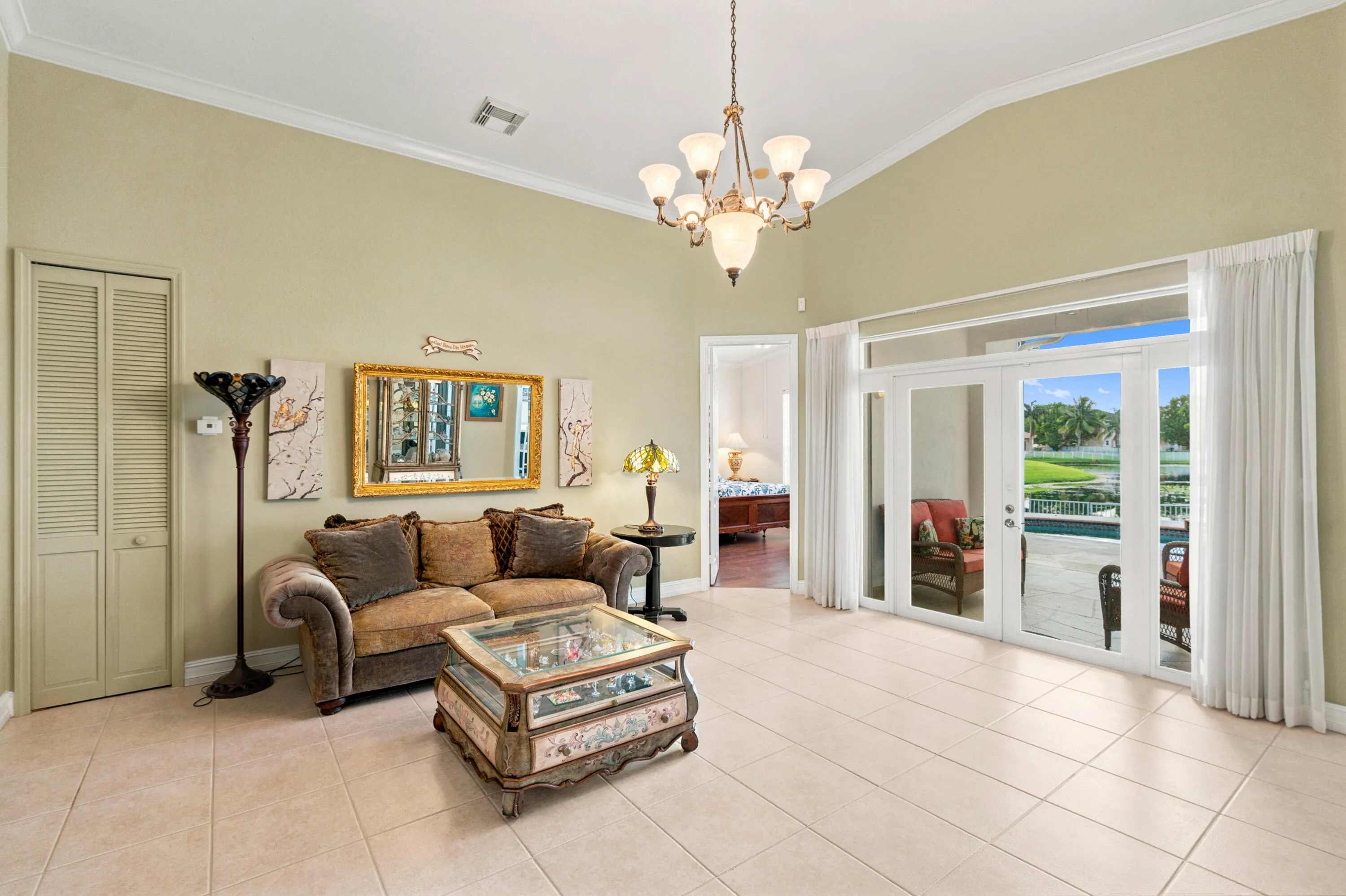 Impact glass doors bring natural light inside while framing views of the pool and water beyond.