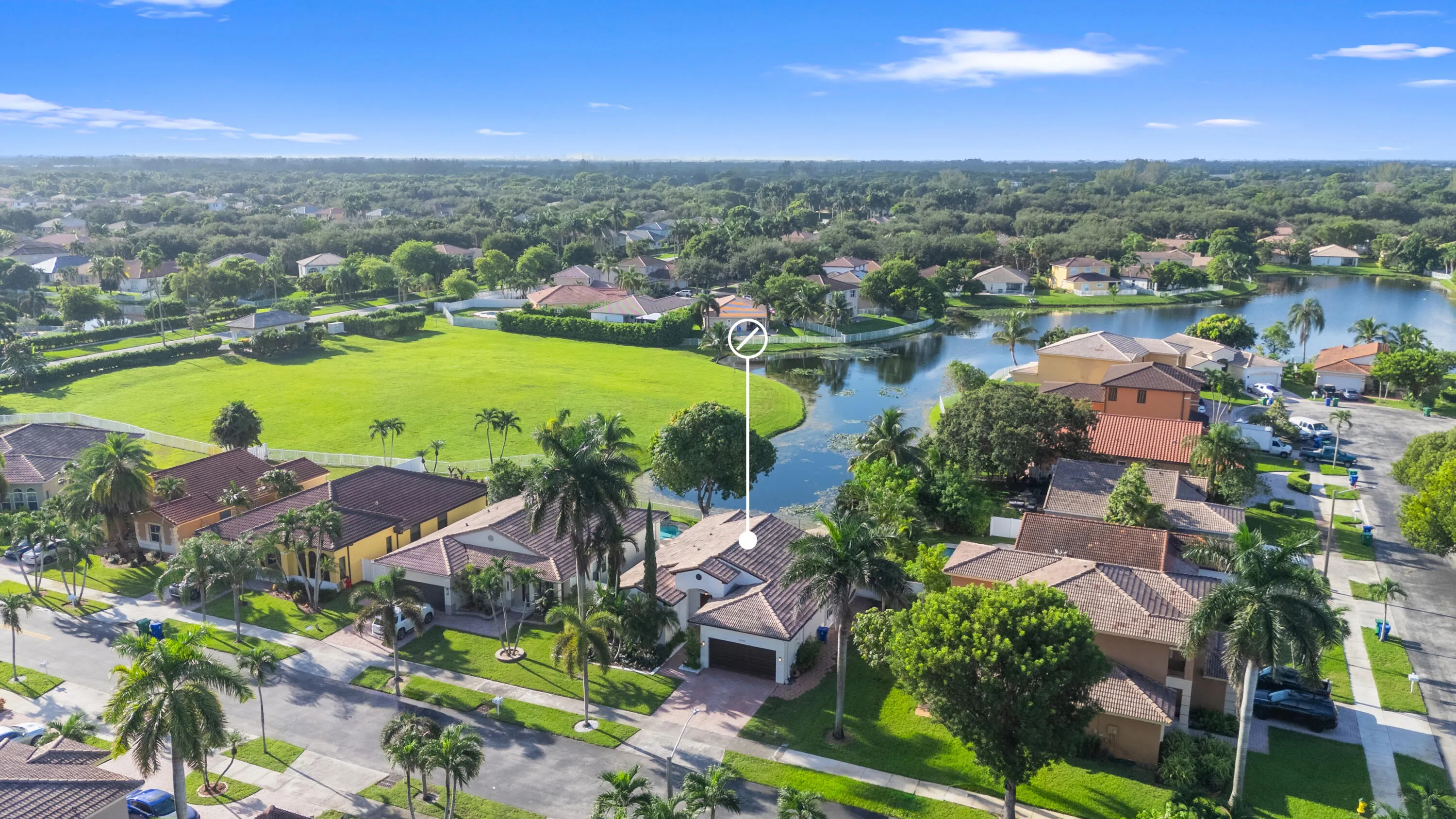 Elevated aerial view places the home within its residential surroundings and highlights the nearby waterway.
