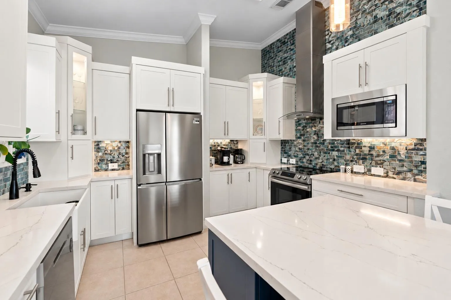 White cabinetry, stainless steel appliances and a statement backsplash create a crisp, contemporary kitchen.