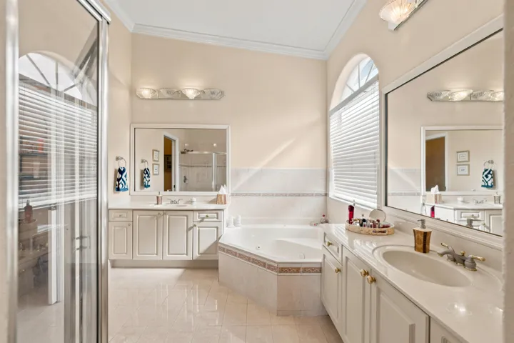 A jetted soaking tub, separate shower and dual vanities create a well-appointed primary bath.