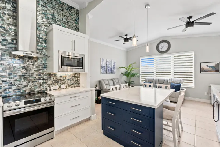 The contrasting center island adds generous workspace and seating within the open kitchen.