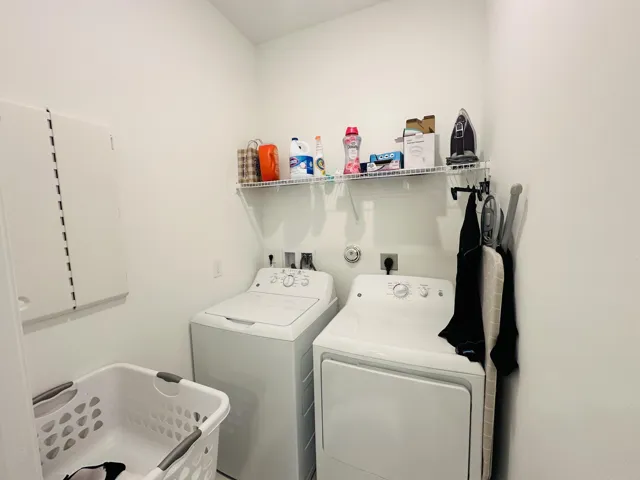 laundry room with built in ironing board in the unit full size washer & dryer