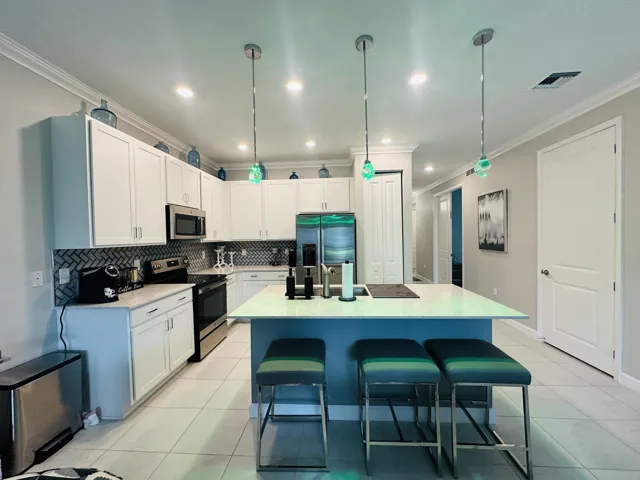 comfortable kitchen with pantry and seating at the counter- great for entertaining- customs lighting and backsplash