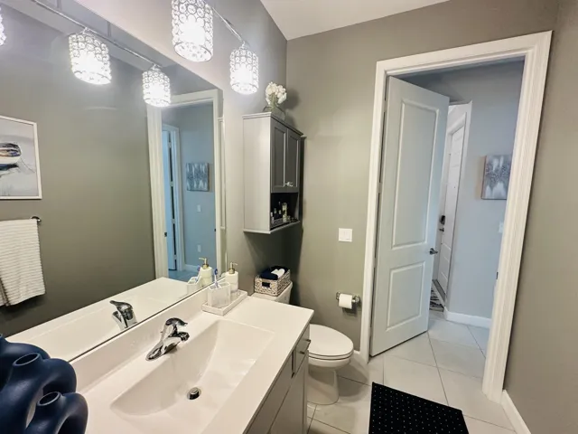 guest bathroom single sink vanity with cabinet over the toilet