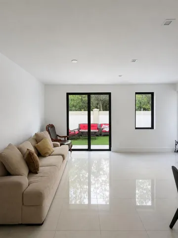 Spacious interior featuring large format tile flooring, recessed lighting, and a sliding glass door