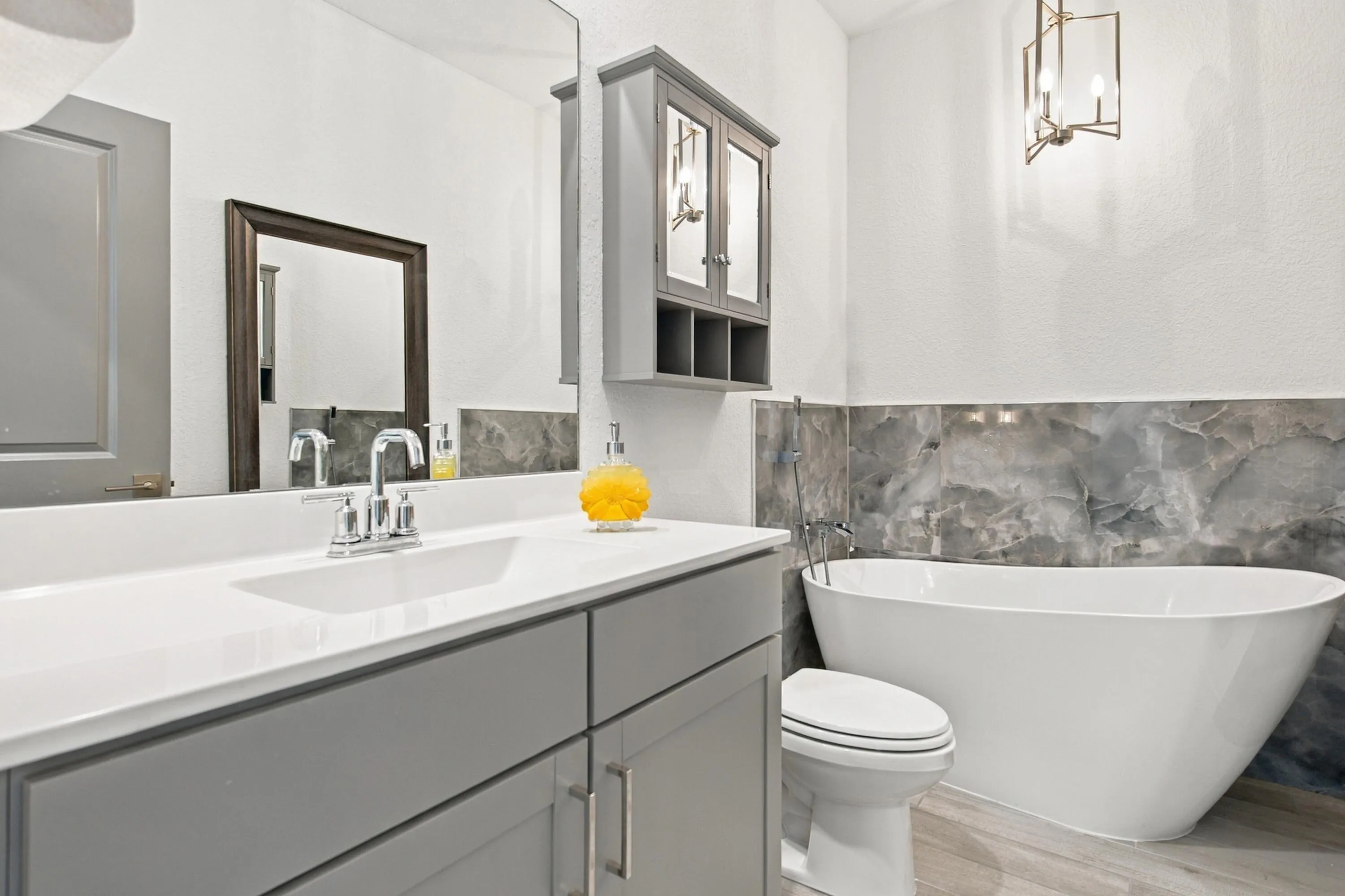 Large bathroom with porcelian soaking tub, recessed lights and newer light fixtures.