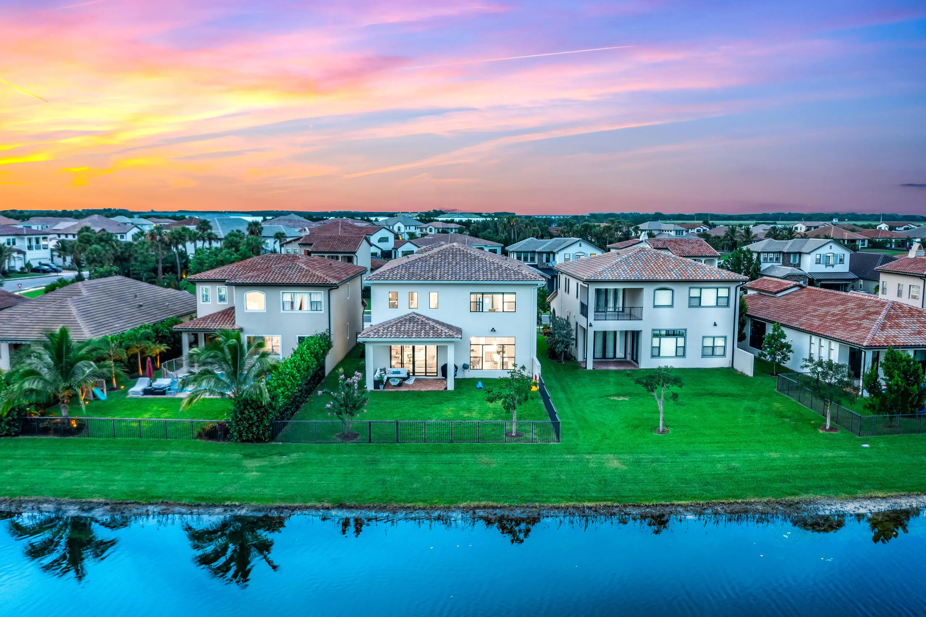 Waterfront property featuring a spacious lawn, private patio, and second-story balcony