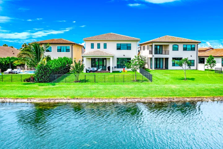 Expansive green lawn with water frontage and mature trees