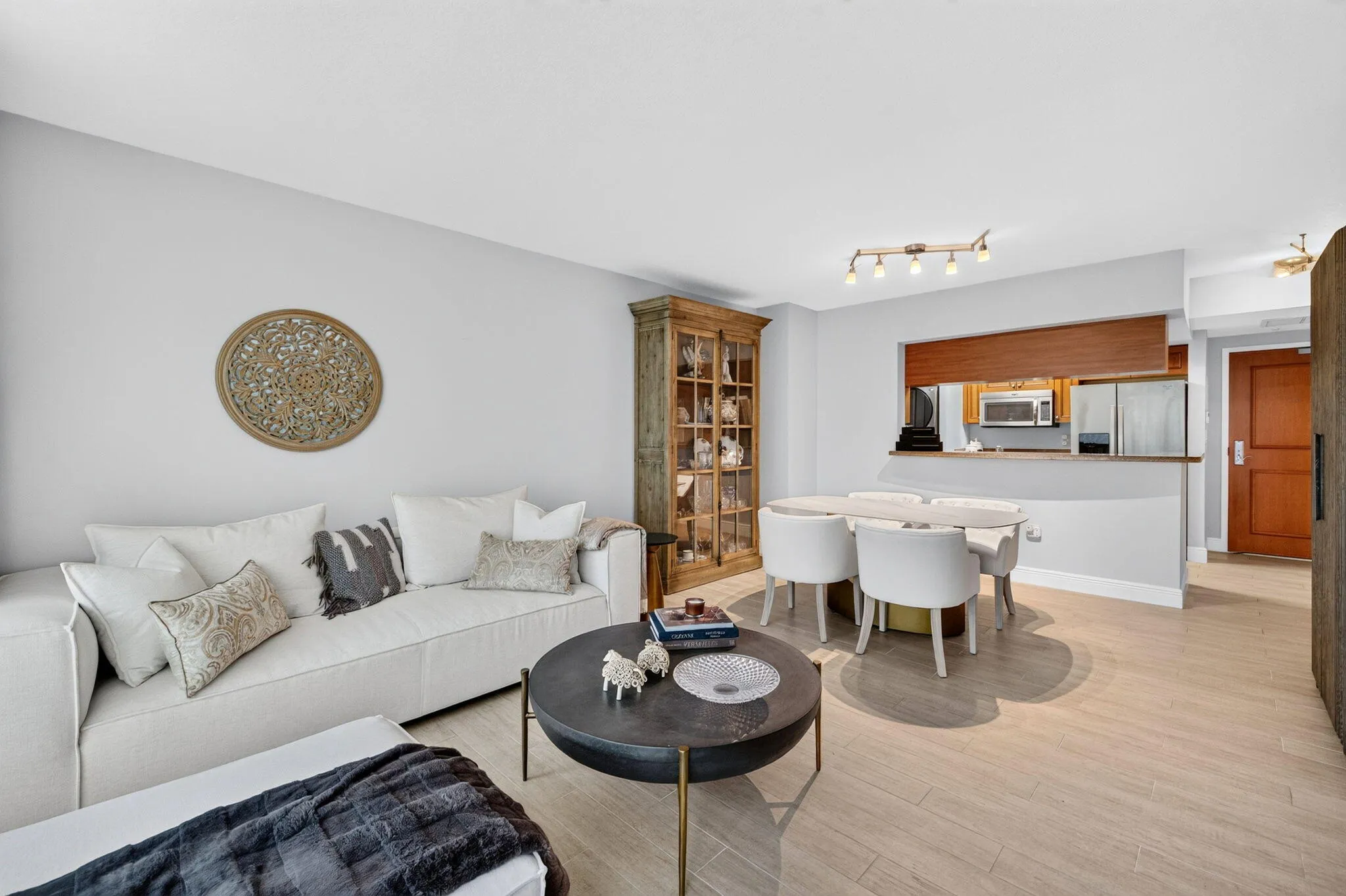 Light-toned tile flooring, recessed kitchen with stainless steel appliances