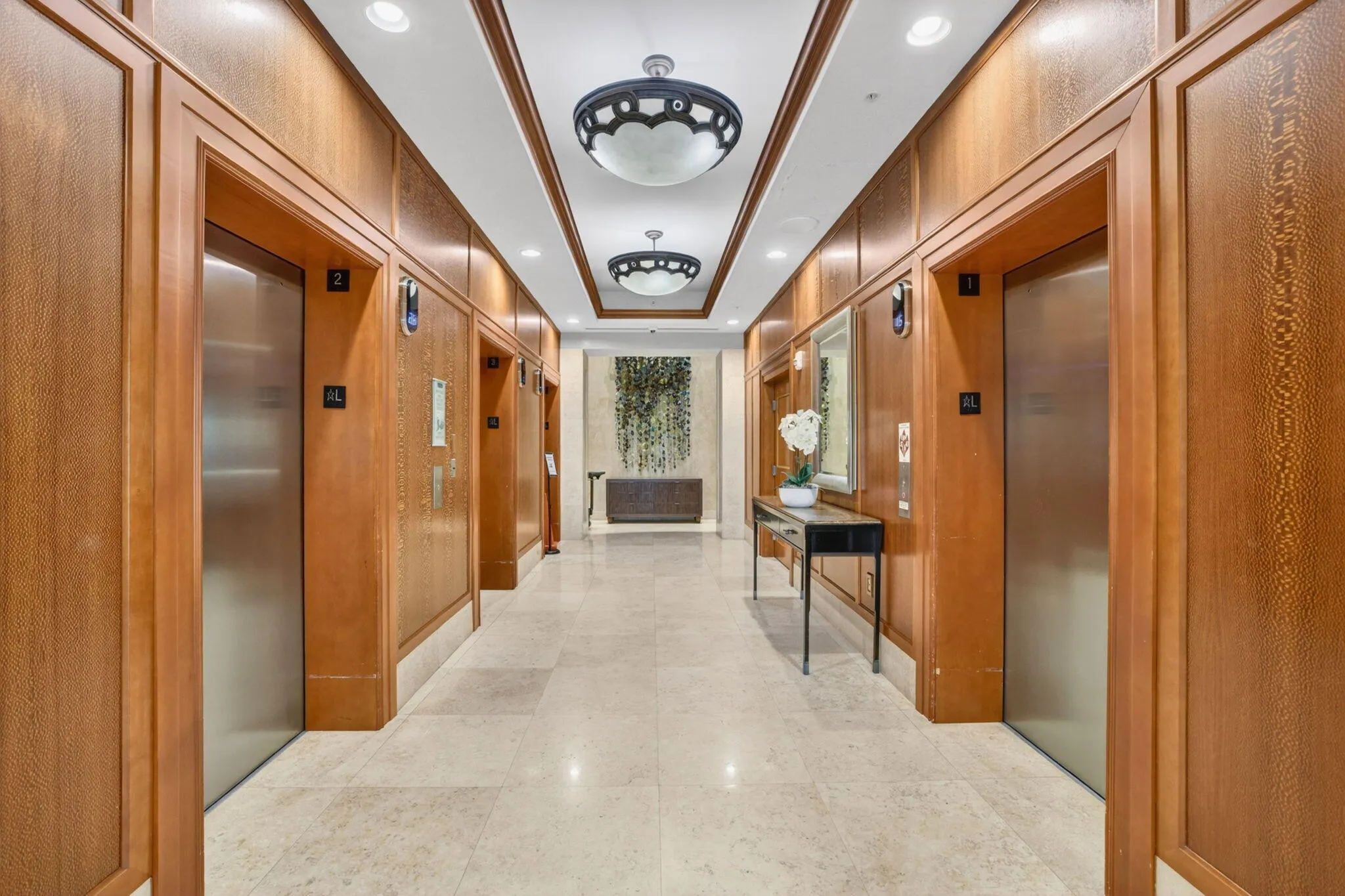 Elevator lobby featuring wood paneling, recessed lighting, and decorative ceiling fixtures