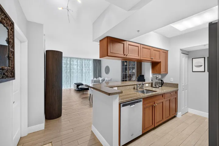 Kitchen featuring wood cabinetry, integrated stainless steel dishwasher, and