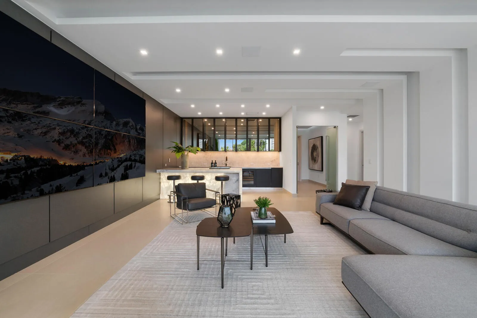 Exceptional first-floor VIP guest suite featuring a spacious private lounge, oversized media wall, full bar, designer finishes, and a private bedroom and bath.