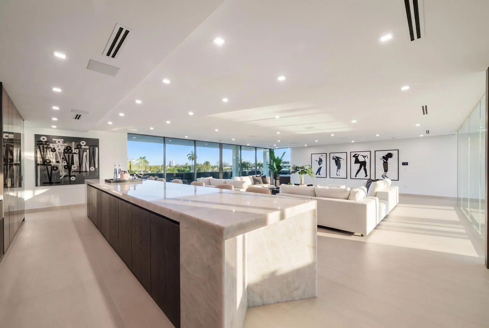 Spectacular third-floor sky lounge anchored by a dramatic illuminated onyx bar, expansive entertaining areas, and walls of glass opening to the terrace.