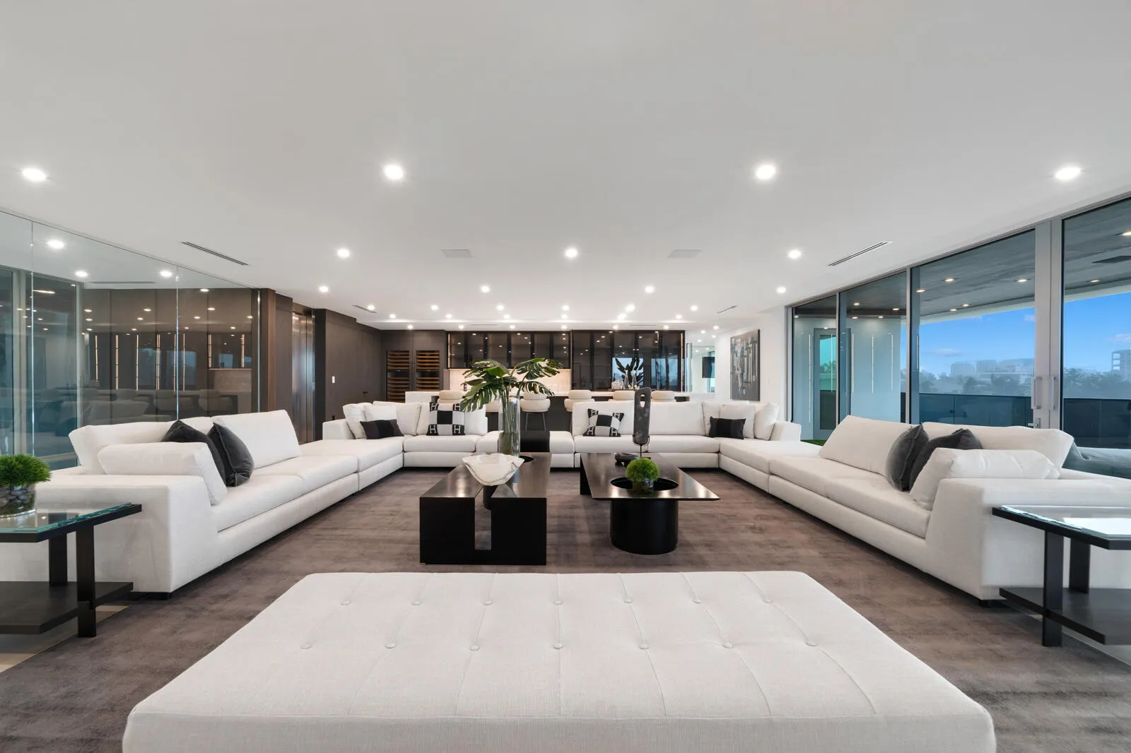 Expansive third-floor entertainment lounge with multiple conversation areas, contemporary designer furnishings, and seamless access to the covered terrace.