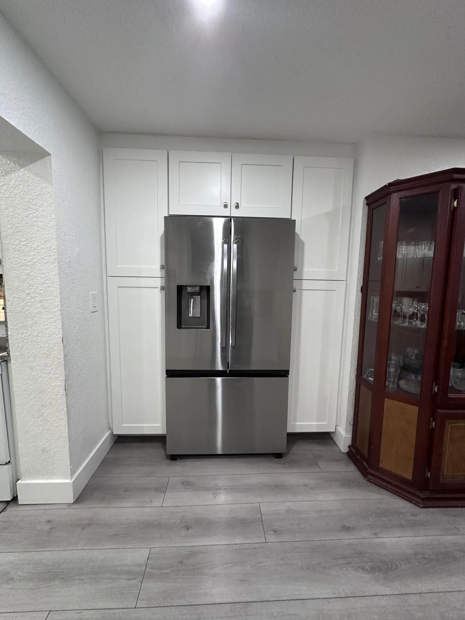 Energy Efficent 2 door fridge with ice maker, pantry cabinetry surrounds the fridge.