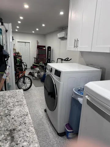 Garage converted into walk-in storage/work out area with separate laundry area.
