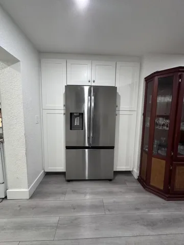 Energy Efficent 2 door fridge with ice maker, pantry cabinetry surrounds the fridge.